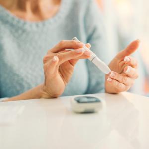 A woman tests her blood sugar. 