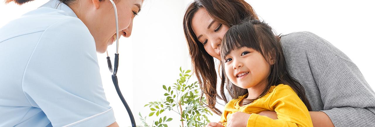 Health care provider using stethoscope on child.