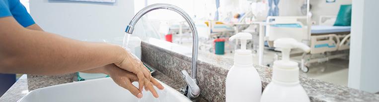 A health care provider washes their hands in a hospital.