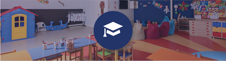 A mortarboard icon overlays a colorful preschool classroom filled with artwork and art supplies, tables and chairs, and riding toys.